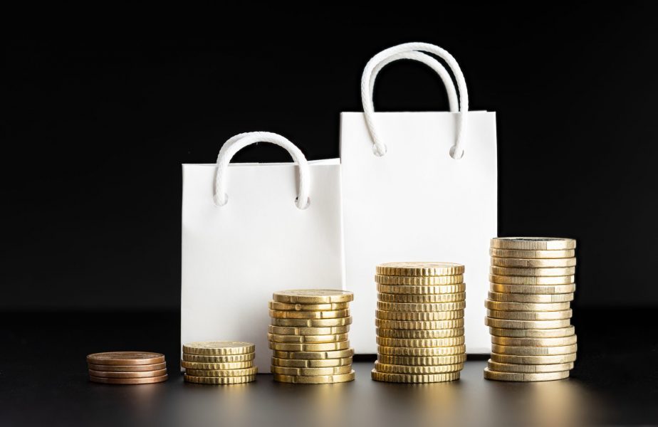 Rising coins and blank shopping bags on black background. Rising prices or inflation concept. Mock up